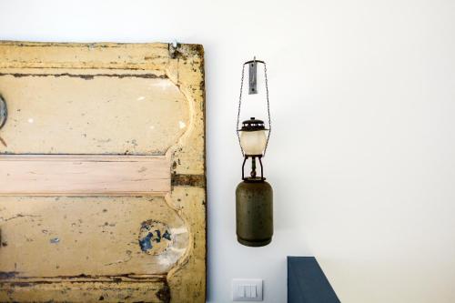 a lamp hanging on a wall next to a box at Dimora di Catullo - Ospitalità di Charme in Palazzolo Acreide