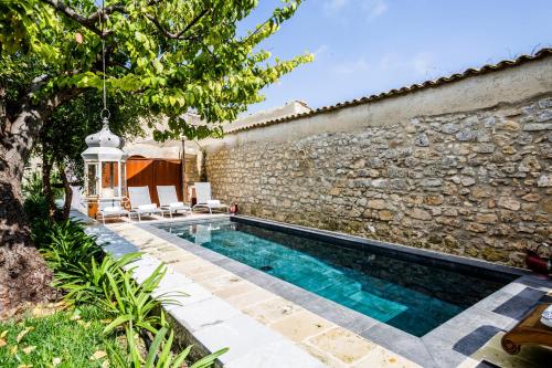 a swimming pool in front of a stone wall at Dimora di Catullo - Ospitalità di Charme in Palazzolo Acreide