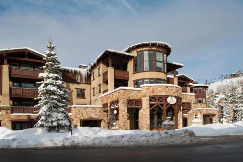 a building in the snow with a tree in front of it at The Chateaux Deer Valley in Park City