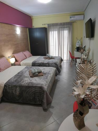 ein Hotelzimmer mit 3 Betten und einem Sofa in der Unterkunft G M 1 ROOMS KENTRO in the heart of the city in Larisa