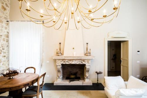a large chandelier in a living room with a fireplace at Dimora di Catullo - Ospitalità di Charme in Palazzolo Acreide