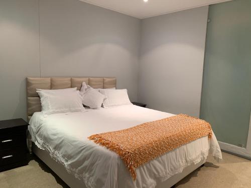 a bedroom with a large bed with white sheets and pillows at Durban Waterfront Apartments in Durban