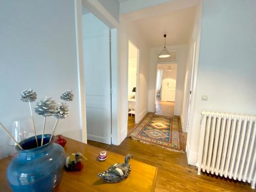 a living room with a vase on a table at Les Chambres de LOUIS in Le Chesnay