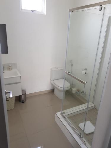 a bathroom with a toilet and a glass shower at ARCHITECTs VIEW - SUIT 2 in Durban