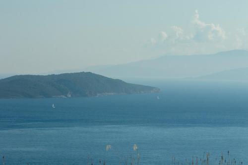 a large body of water with mountains in the background at Ionian View Villas in Sivota