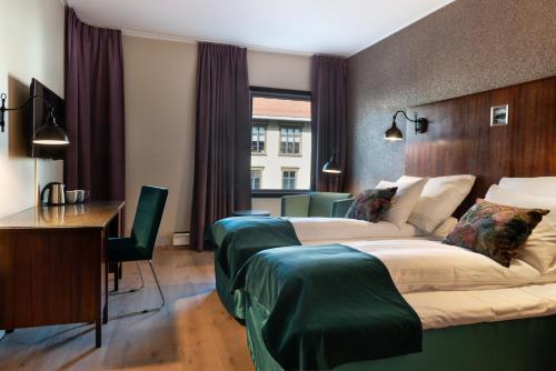 a hotel room with two beds and a desk at Quality Hotel Grand Kongsberg in Kongsberg