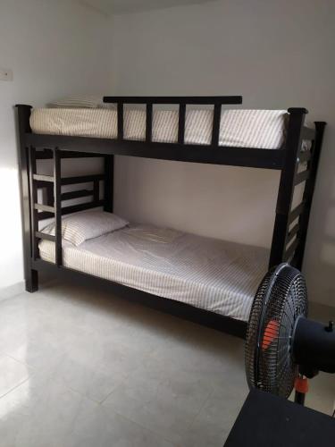 two bunk beds in a room with a fan at Emvacamo' in Taganga