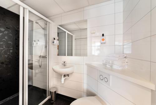 Baño blanco con aseo y lavamanos en Quality Hotel Grand Kongsberg, en Kongsberg