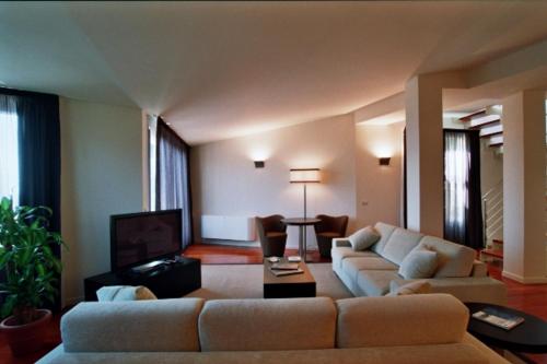 uma sala de estar com um sofá e uma televisão em Eden Rock Resort em Florença