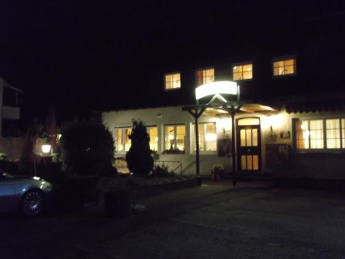 a lit up house at night with a car parked in front at Gasthaus Vogelgarten in Eislingen