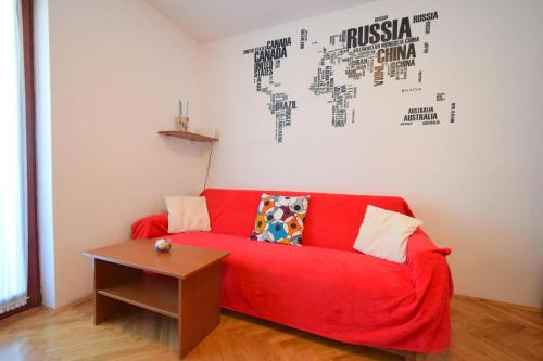 un sofá rojo en una sala de estar con mesa en Apartment Zdenka, en Njivice