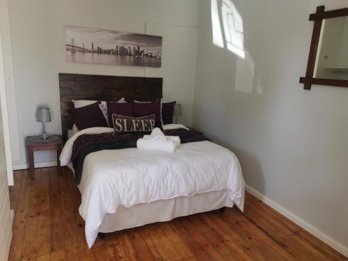a bedroom with a large bed with white sheets at 420 on Cape in Port Elizabeth