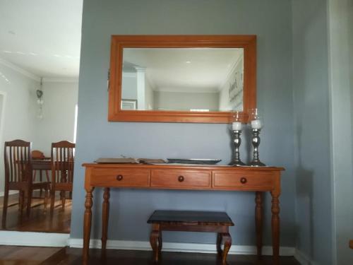 a wooden dresser with a mirror on a wall at 420 on Cape in Port Elizabeth