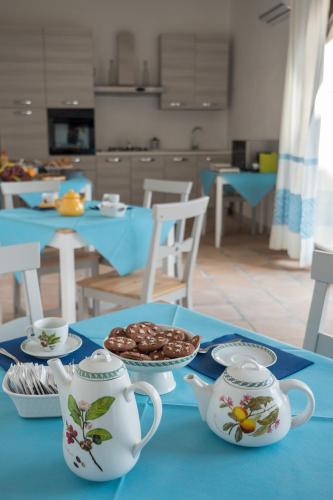 a blue table with two tea cups and a plate of food at Villa Chiara in Villamar