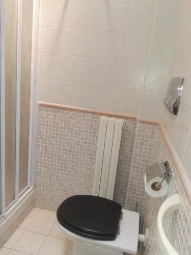 a bathroom with a toilet with a black lid at La terrazza di Maja in Chieti