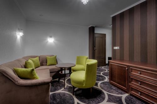 a living room with a couch and a table and chairs at Evita Hotel & SPA in Tleń