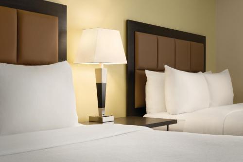 a hotel room with two beds and a lamp at Park Inn by Radisson, Calgary Airport North, AB in Calgary