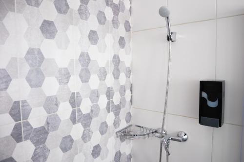 a shower with a microphone in a bathroom at AM Hostel in Sliema