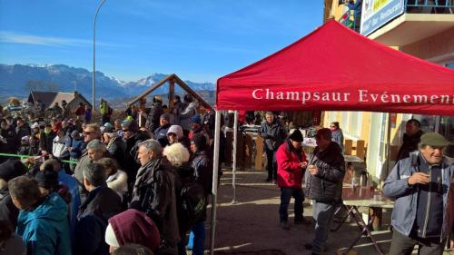 a crowd of people standing under a red tent at Les Fauvettes in Saint-Léger-les-Mélèzes