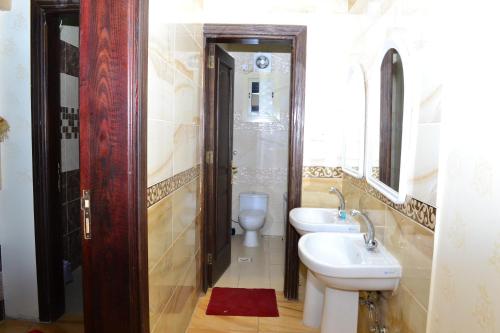 a bathroom with a sink and a toilet and a mirror at Durat Al Ruwmansiya 3 in Tabuk