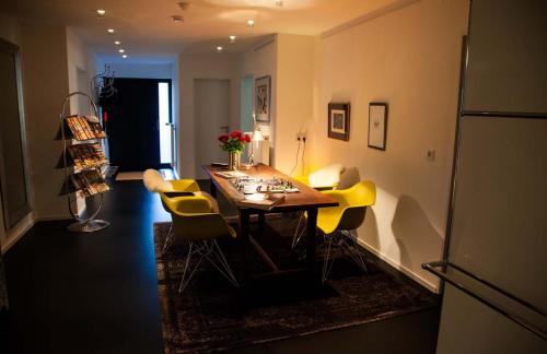 a dining room with a table and yellow chairs at the birdy mountains luxury lodge 146qm, Sauna, Entertainment in Schlitz