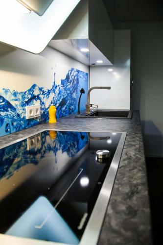 a kitchen with a sink and a counter top with blue tiles at the birdy mountains luxury lodge 146qm, Sauna, Entertainment in Schlitz