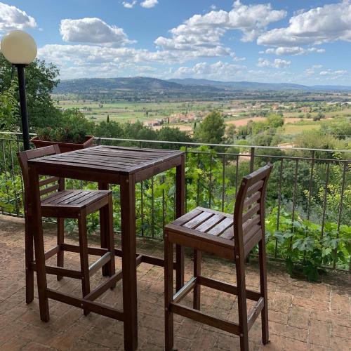 a wooden table and chairs on a balcony with a view at SetterHouseAgriHotel in Trevi