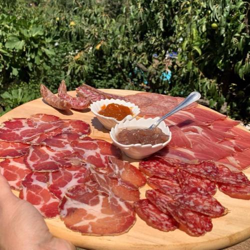a cutting board with cured meats and sauce on it at SetterHouseAgriHotel in Trevi
