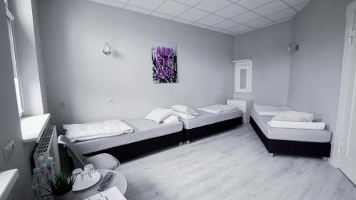 um quarto com duas camas e um quadro na parede em Rooms Śląska em Bydgoszcz