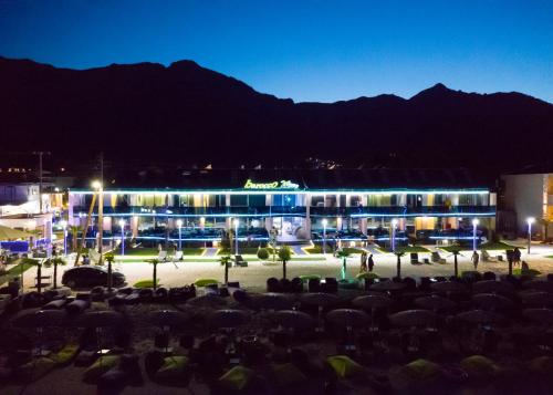 a group of people sitting in front of a building at night at Barocco Wave Hotel in Skala Potamias