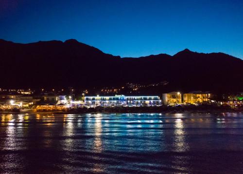 a city lit up at night next to a body of water at Barocco Wave Hotel in Skala Potamias