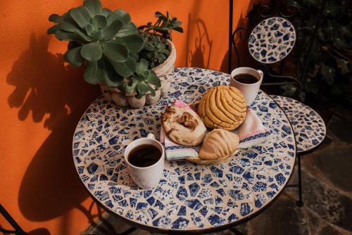 a table with a plate of food and two cups of coffee at TIERRA SOÑADA HOTEL BOUTIQUE in Tepatitlán de Morelos