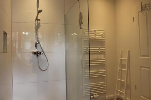 a bathroom with a shower with a glass door at De Wümmestuuv in Fischerhude