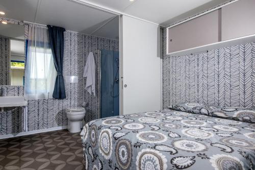 a bedroom with a bed and a bathroom with a toilet at Camping Union Lido in Cavallino-Treporti