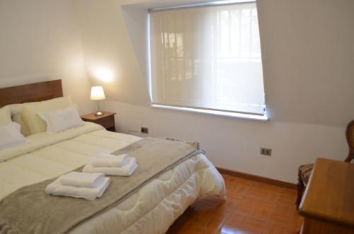 a bedroom with a bed with two towels on it at Los Araucanos in Santiago