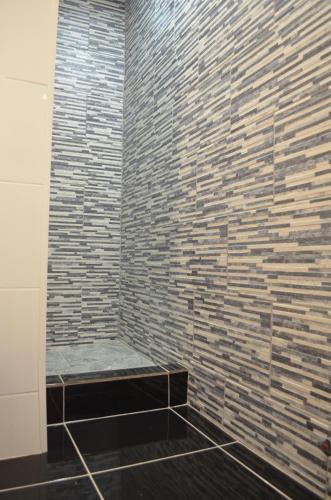 a bathroom with a brick wall and a bench at Los Araucanos in Santiago