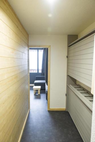 un couloir avec une chambre dotée d'un canapé et d'une fenêtre dans l'établissement Studio 4 personnes fraichement rénové au pied des pistes à Valfréjus, à Valfréjus