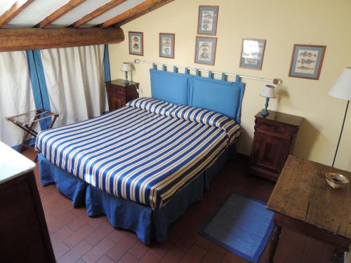 a bedroom with a blue bed with a striped bedspread at Fattoria di Migliarino in Migliarino