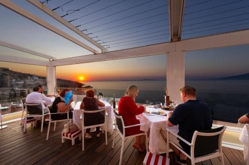 un gruppo di persone seduti a un tavolo su un balcone di Hotel Continental a Sorrento