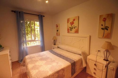 um quarto com uma cama e uma janela em Apartamento Jardín del golf 2 em Chiclana de la Frontera