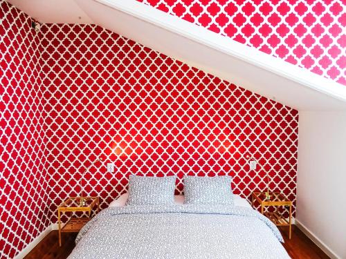 a bedroom with a red patterned wall with a bed at SUPERNOVA Hostel in Porto