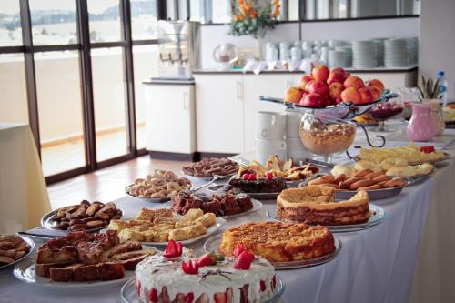 聖若阿金的住宿－São Joaquim Park Hotel，一张桌子,上面放着许多不同类型的蛋糕和馅饼