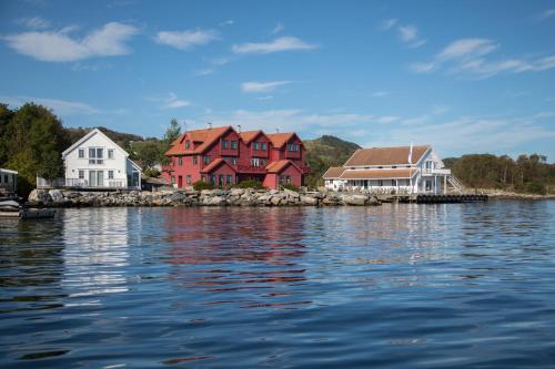 een groep huizen aan de oever van een waterlichaam bij Sjøberg Ferie og Hotell in Østhusvik