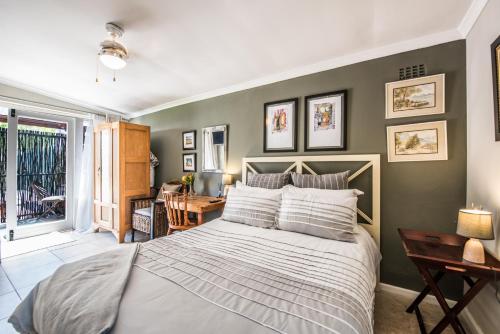 ein Schlafzimmer mit einem großen Bett und einem Schreibtisch in der Unterkunft Greenlawns B&B in Kapstadt
