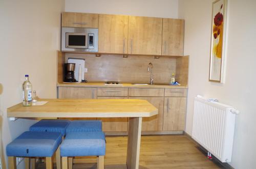 uma cozinha com uma mesa de madeira e bancos azuis em Landhaus Nütschau em Bad Oldesloe