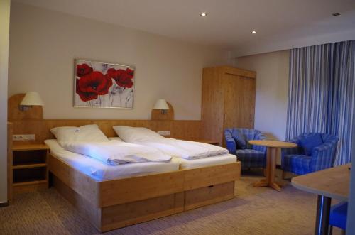 um quarto de hotel com uma cama, uma mesa e cadeiras em Landhaus Nütschau em Bad Oldesloe