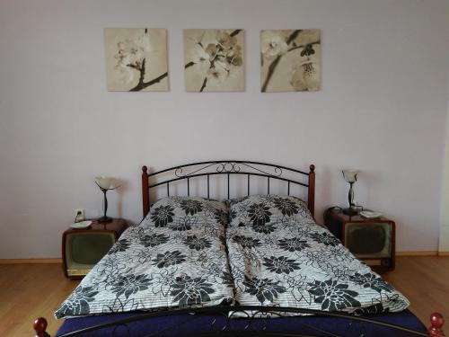 a bed in a bedroom with three pictures on the wall at art-house 2 in Děčín