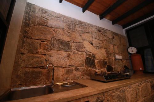 a kitchen with a stone wall and a sink at Willow's Abode in Kandy