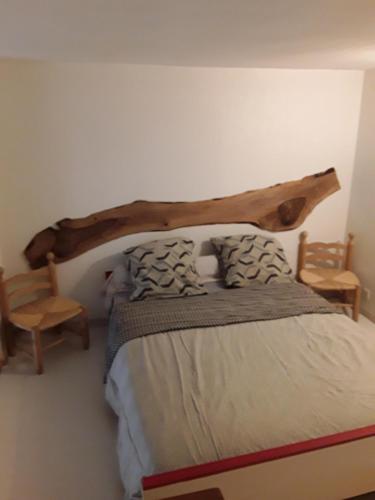 ヴァル・レ・バンにあるAppartement Spacieux Valsoisのベッドルーム1室(大きな木製ヘッドボード付きのベッド1台付)