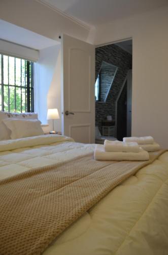 a white bedroom with two beds and a fireplace at Los Araucanos in Santiago